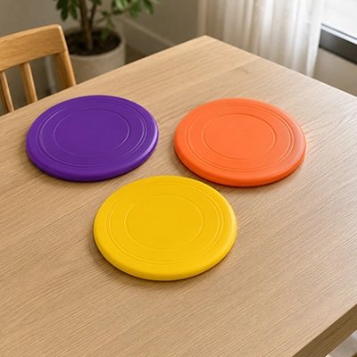Frisbee chien trois colories sur table